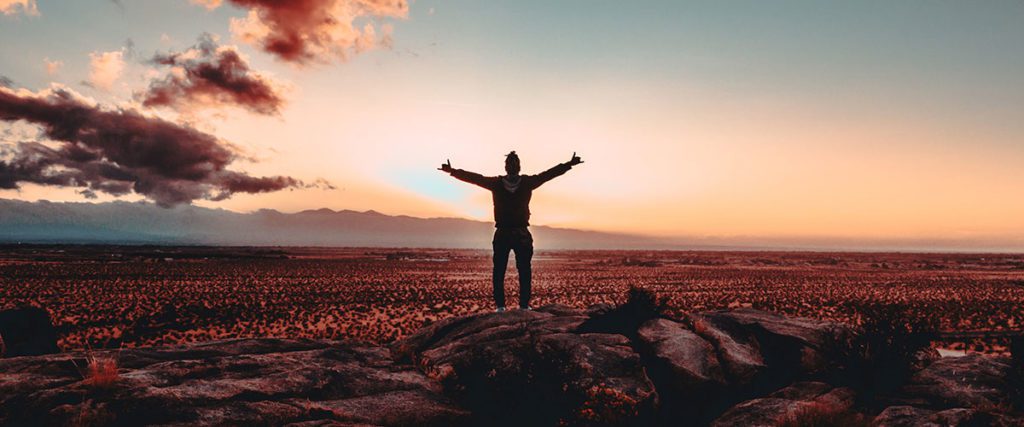 Man standing on the mountain at sunset